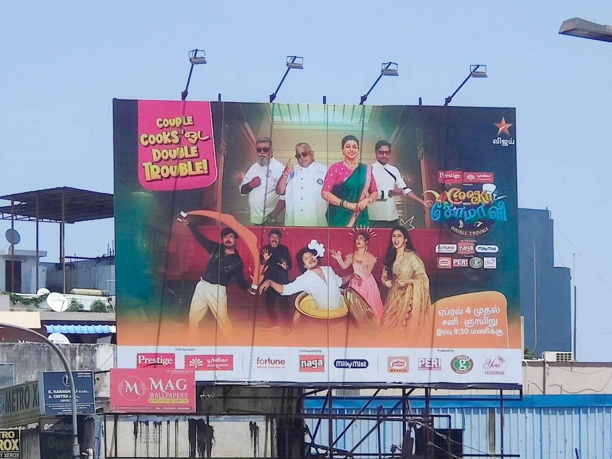 Large outdoor billboard advertising a restaurant with colorful images of food and smiling people in casual dining attire