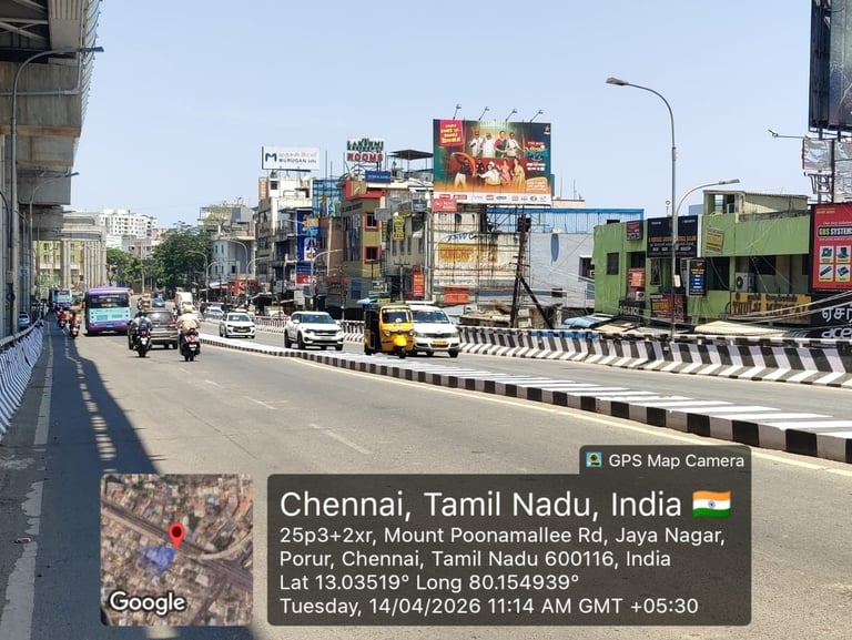 Busy road intersection in Chennai with buildings, vehicles, and shops
