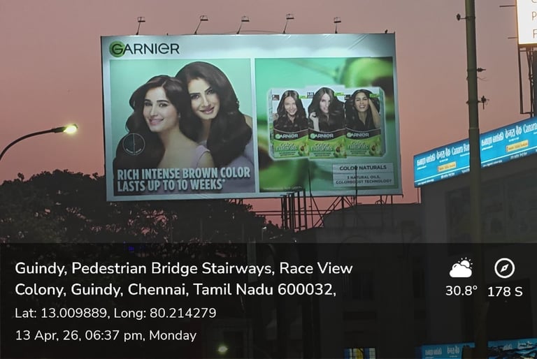 Garnier hair color product billboard advertisement at dusk showing women with rich brown hair color in Guindy, Chennai