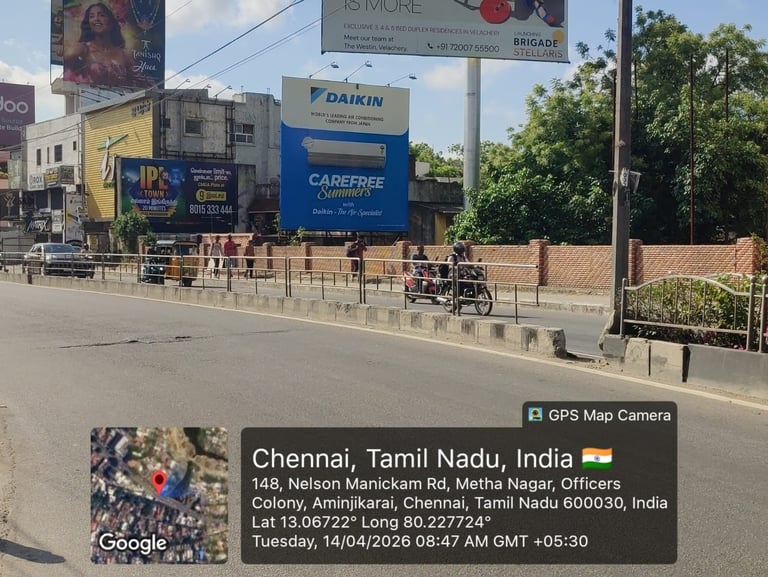 Street view of Chennai with Daikin billboard, commercial buildings, and construction barriers on Nelson Manickom Road