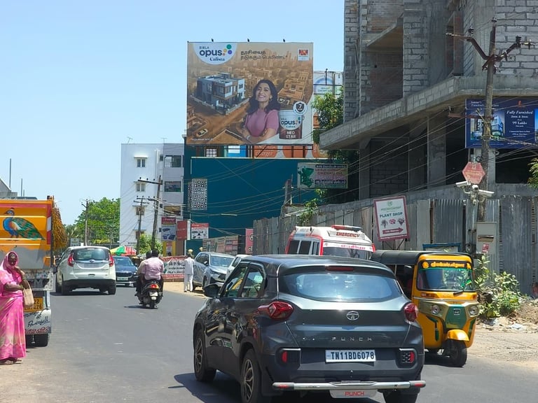 Urban street scene with vehicles, billboards, and multi-story buildings in India