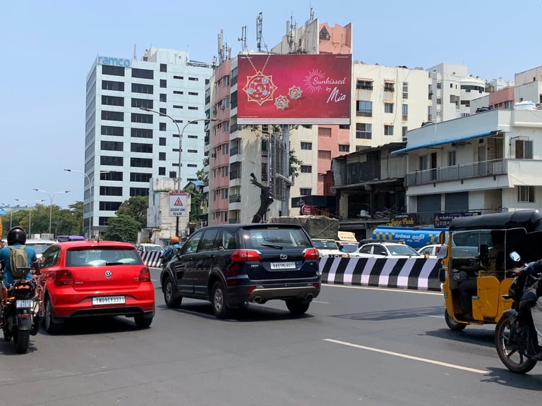 Urban street scene with cars, auto-rickshaw, and buildings in an Indian city intersection