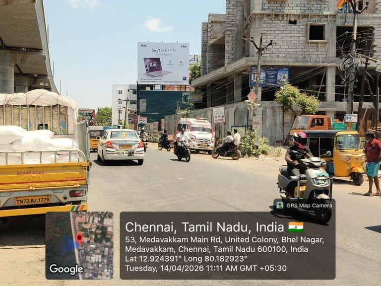 Busy street scene in Chennai, India with auto-rickshaws, motorcycles, trucks, and buildings under construction on a sunny day