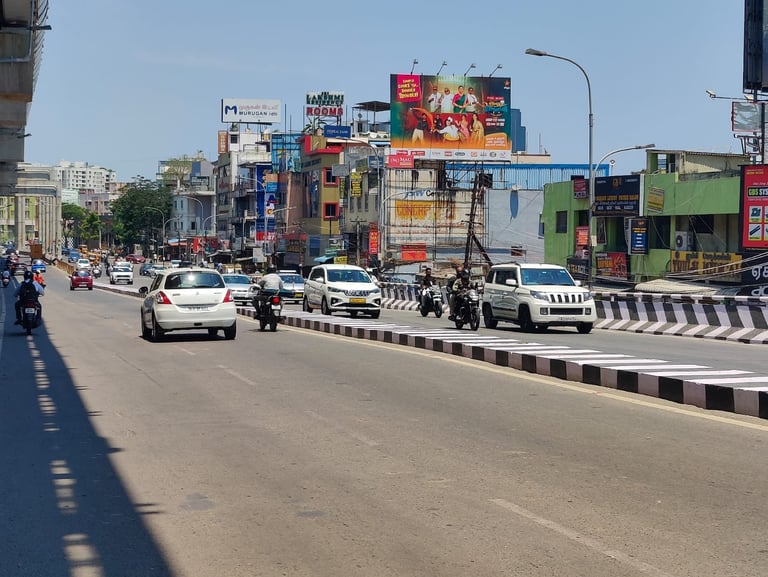 Urban street with vehicles on multi-lane road, colorful billboards and shops